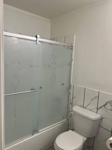 a bathroom with a toilet and a shower