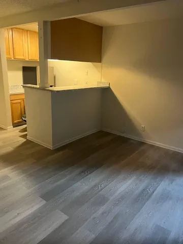 a view of a kitchen with wooden floor and a sink