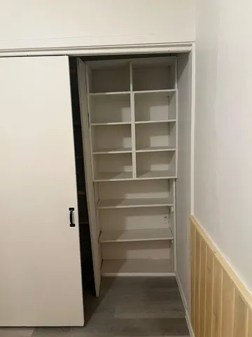 a view of walk in closet with empty racks