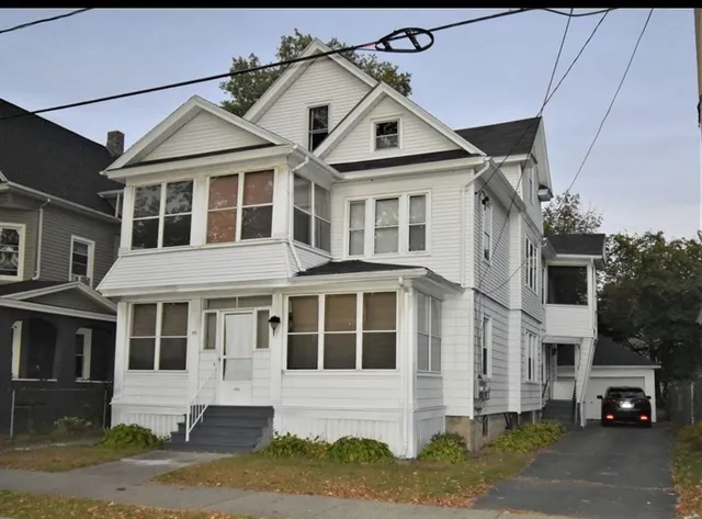 a car parked in front of a white house