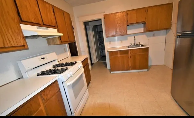 a kitchen with stainless steel appliances a stove a refrigerator and a sink