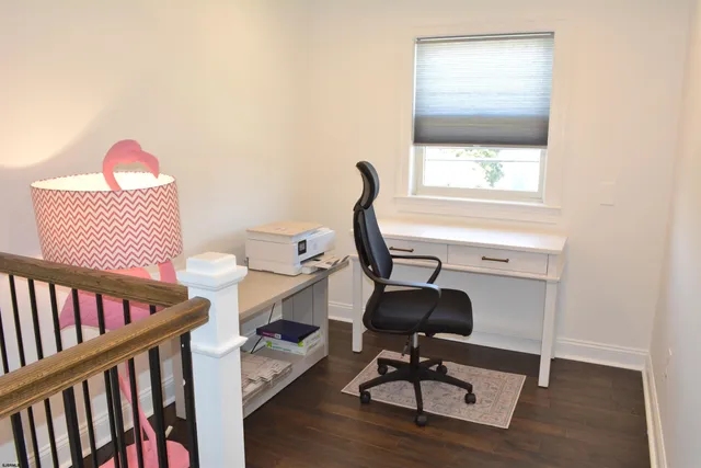 a view of a workspace with furniture and a window
