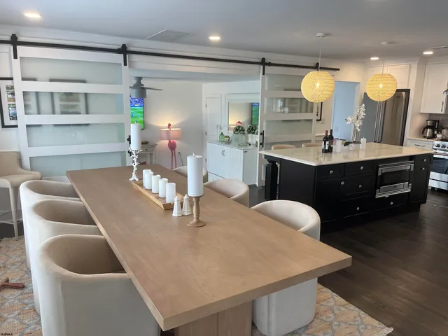 a kitchen with a table chairs sink and wooden floor