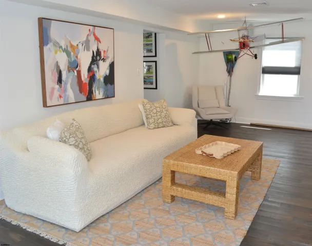 a living room with furniture and a wall painting