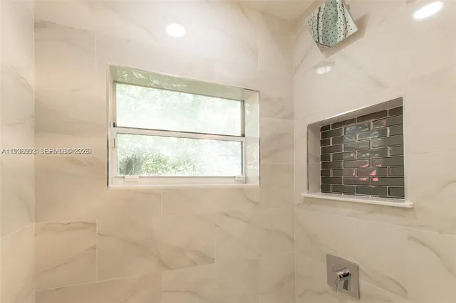 a bathroom with a window and a shower