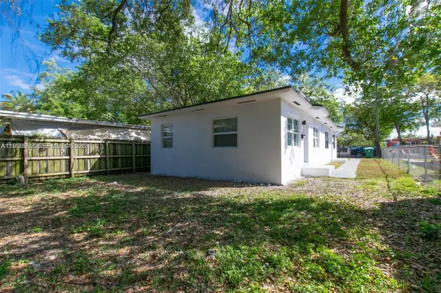 a view of backyard of house with green space