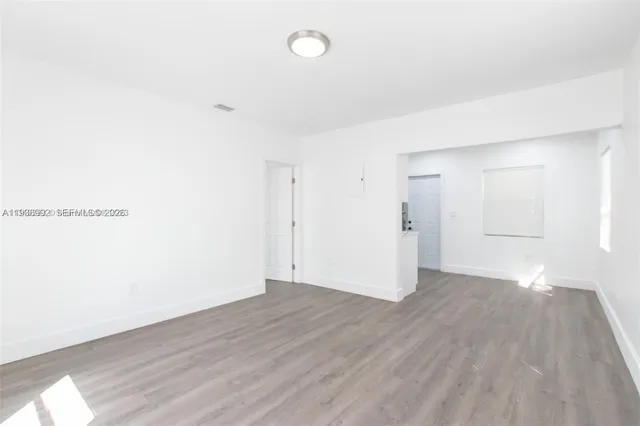 a view of an empty room with wooden floor