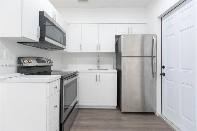 a kitchen with a refrigerator sink stove and cabinets