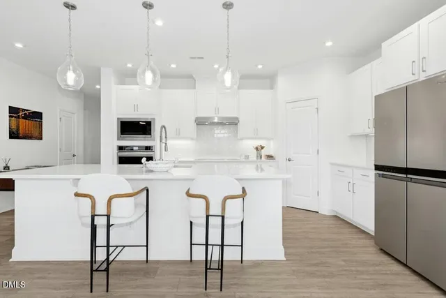 a kitchen with white cabinets and refrigerator
