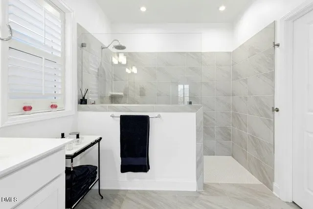 a bedroom with a bed and a dresser next to a window