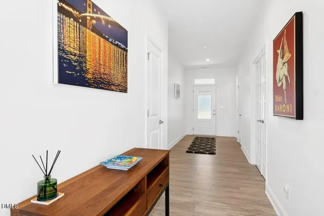 a hallway with front door wooden floor and windows