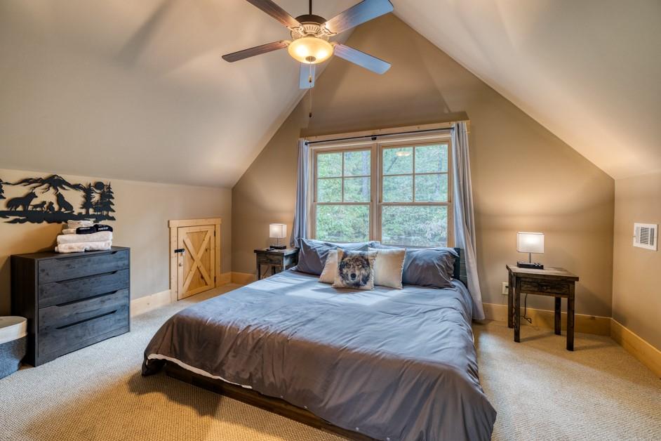 111 Watkins Farm Road Blue Ridge, GA 30513 - Photo 15 of 23 a bedroom with a bed and a chandelier