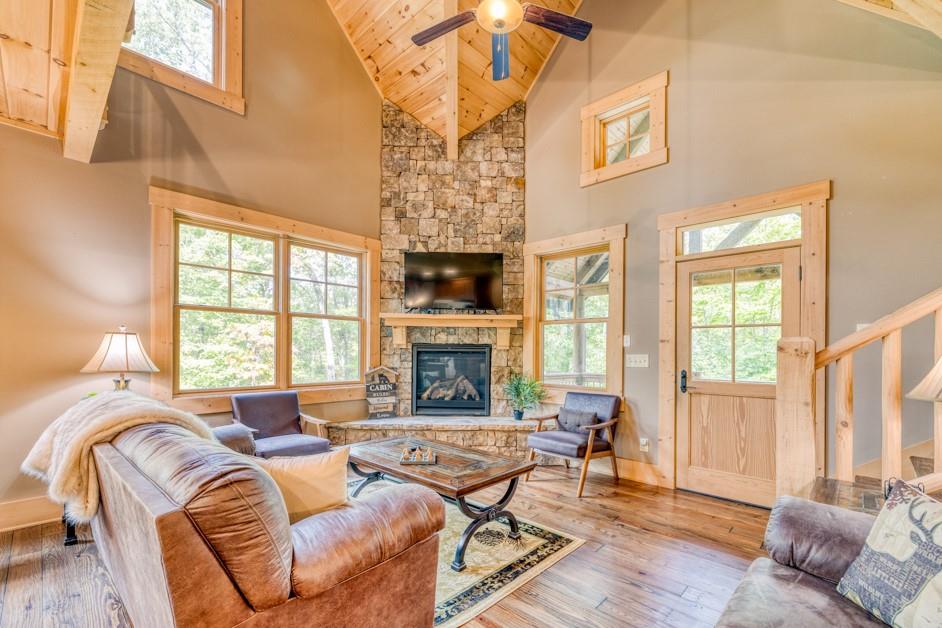 111 Watkins Farm Road Blue Ridge, GA 30513 - Photo 5 of 23 a living room with furniture a fireplace and a floor to ceiling window