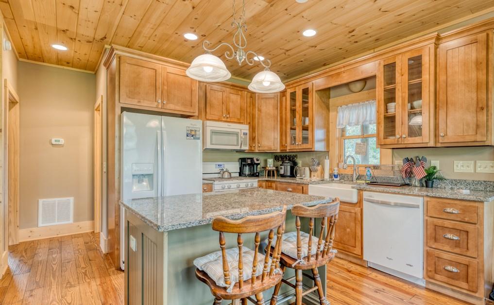 111 Watkins Farm Road Blue Ridge, GA 30513 - Photo 6 of 23 a kitchen with granite countertop a table chairs stove and cabinets