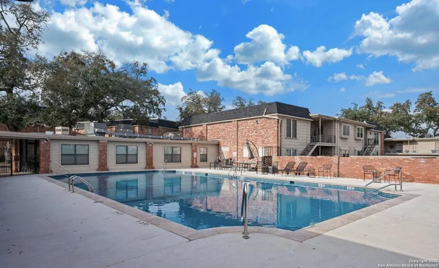 a view of a patio with table and chairs potted plants with floor to ceiling window