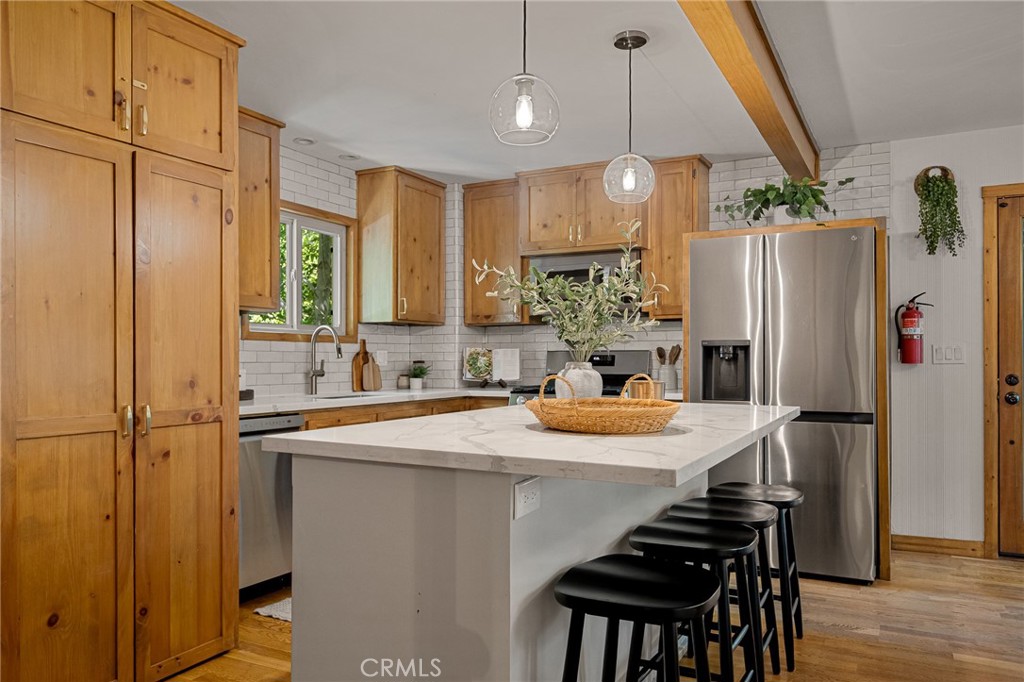 a kitchen with stainless steel appliances granite countertop a sink refrigerator and cabinets