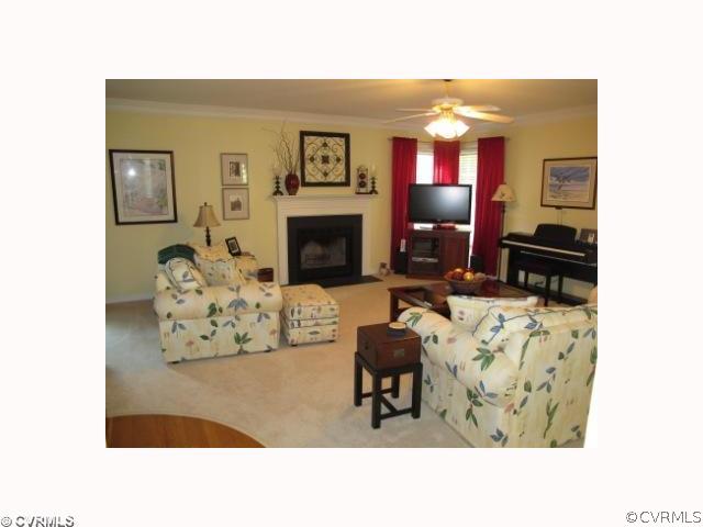 15219 Windy Ridge Road Midlothian, VA 23112 - Photo 4 of 12 a living room with furniture a fireplace and a flat screen tv