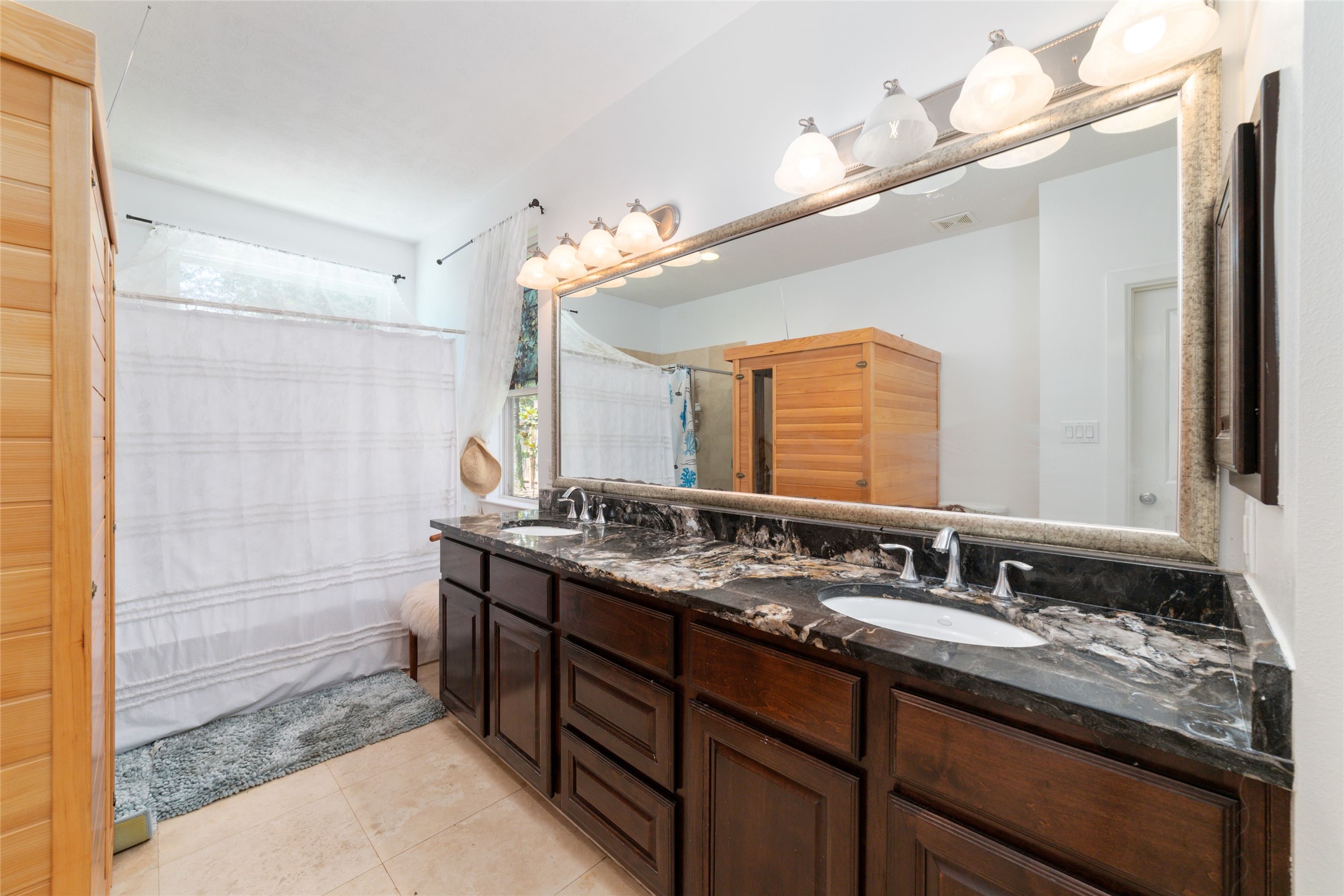 335 Voss Road Houston, TX 77024 - Photo 29 of 45 a bathroom with a granite countertop double vanity sink and a mirror