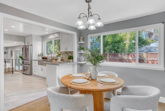 a dining room with furniture a large window and wooden floor