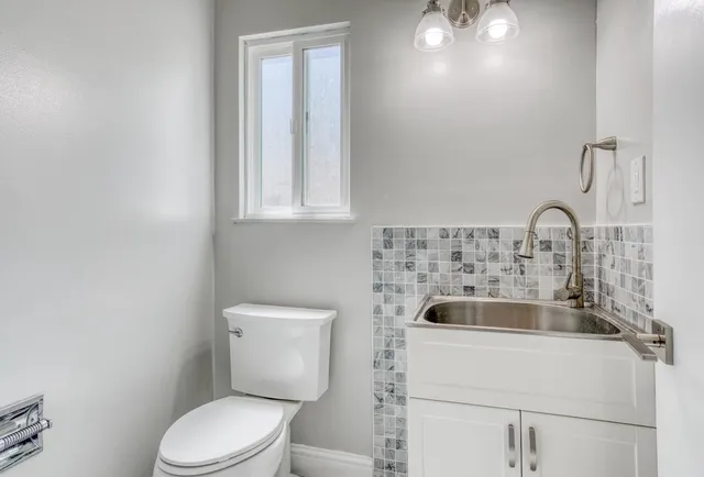 a bathroom with a toilet sink and mirror