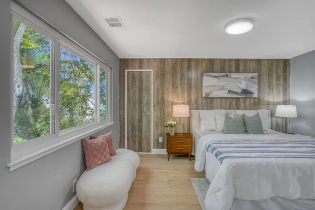 a bedroom with a bed and a large window