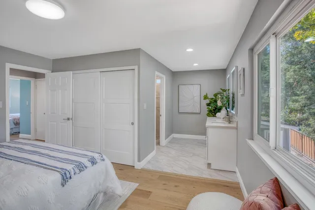 a spacious bedroom with a bed and a potted plant