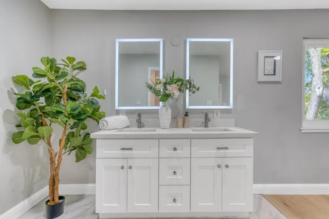 a bathroom with cabinets a plant and a wooden floor