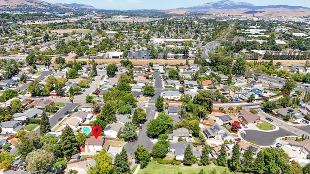 an aerial view of residential houses with outdoor space and trees