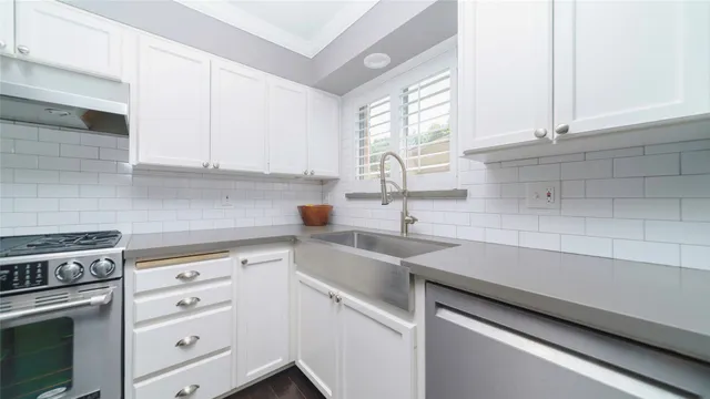 a kitchen with cabinets appliances a sink and a window