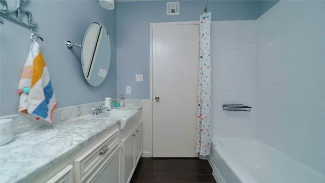 a bathroom with a granite countertop sink and a mirror