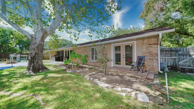 a view of a house with backyard and a tree