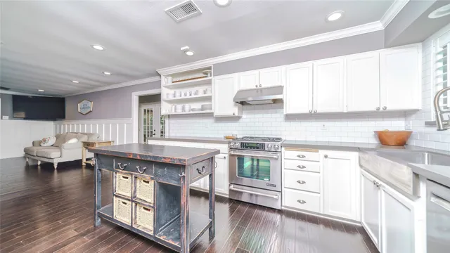 a kitchen with stainless steel appliances granite countertop a stove and a wooden floors