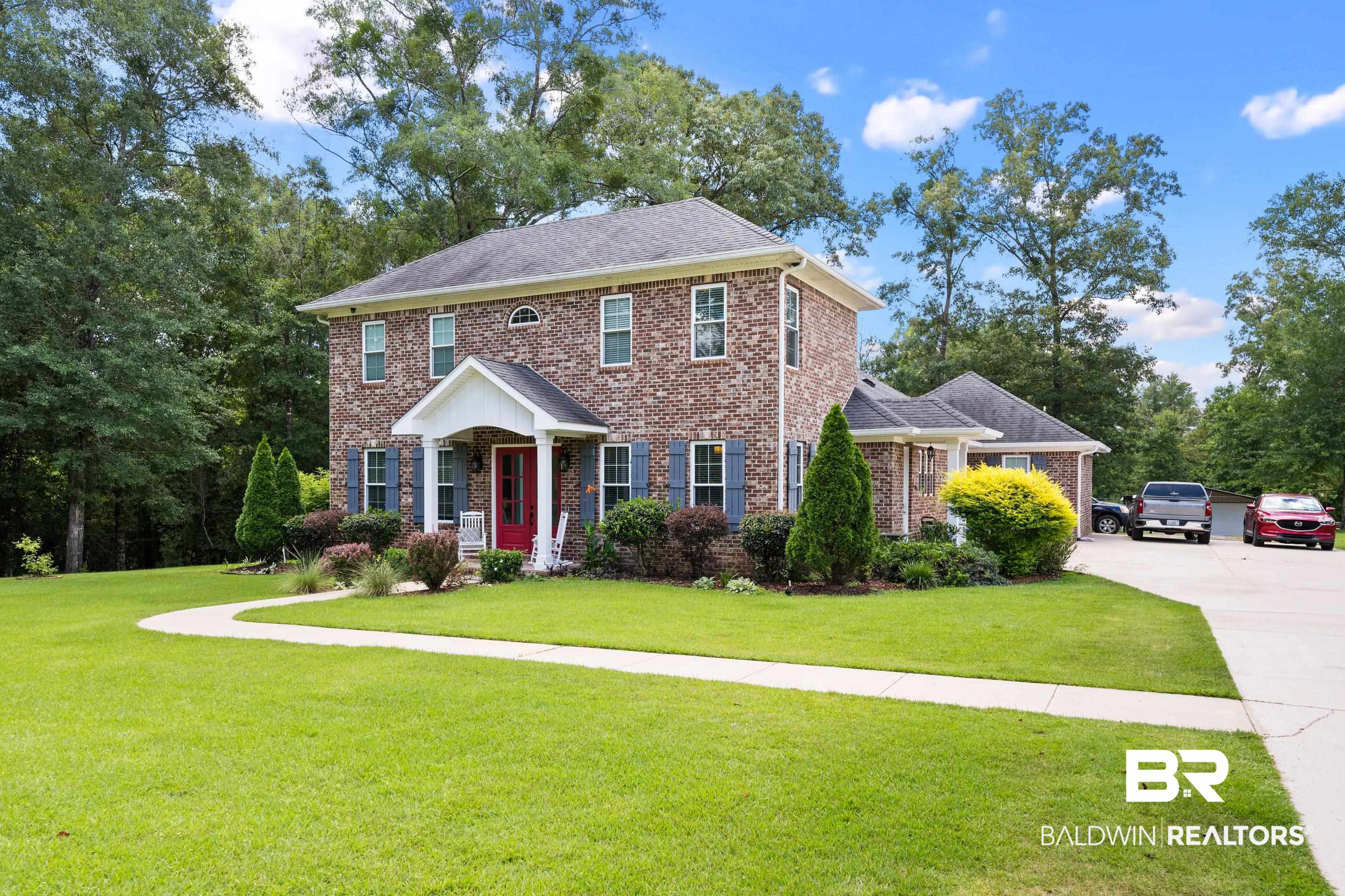 9060 Bromley Road Bay Minette, AL 36507 - Photo 4 of 63 Colonial-style house featuring a front lawn, brick siding, and concrete driveway