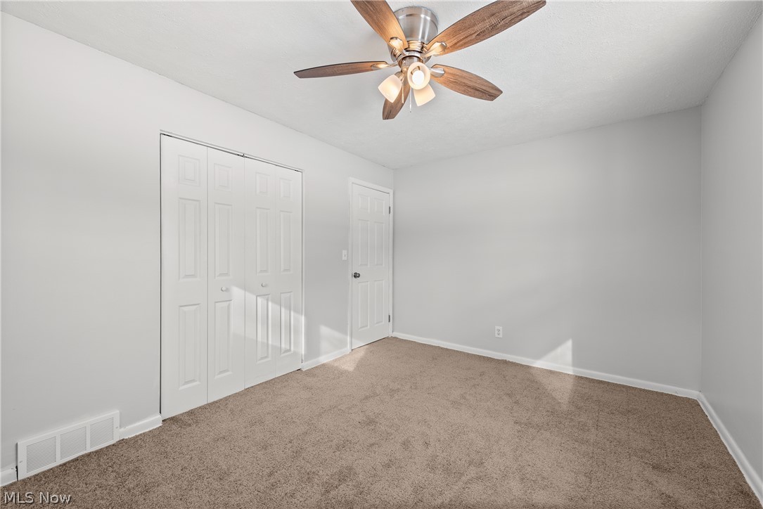 8760 Priem Road Strongsville, OH 44149 - Photo 14 of 29 Unfurnished bedroom featuring ceiling fan, carpet floors, and a closet