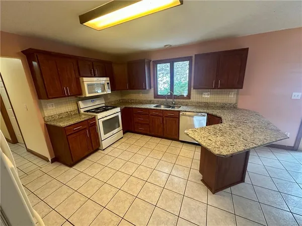 a kitchen with stainless steel appliances granite countertop a stove a sink dishwasher and a refrigerator