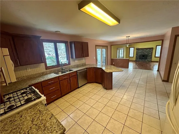 a large kitchen with stainless steel appliances granite countertop a stove a sink and a microwave