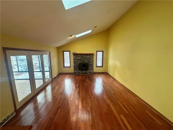 a view of empty room with wooden floor and fireplace