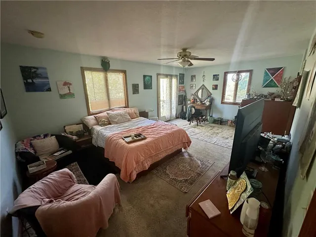 a bedroom with bed couch and window