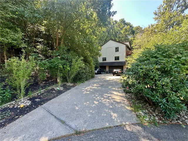a front view of a house with a yard and trees