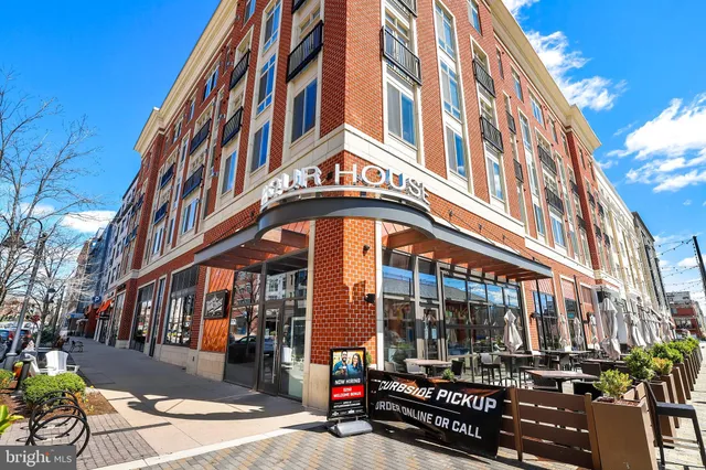 a view of a fountain in front of a brick house with a big yard