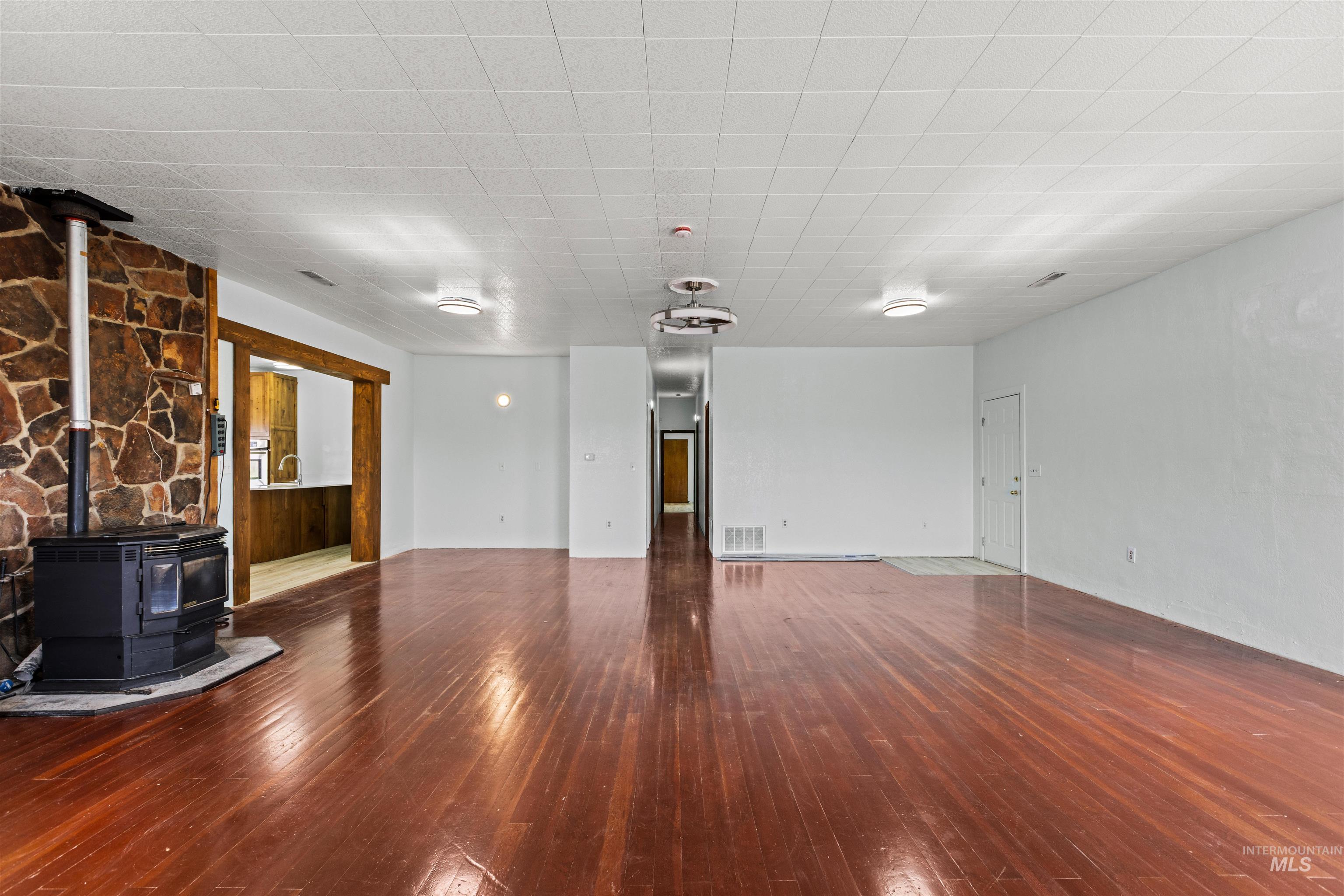 5168 South Jump Creek Road Marsing, ID 83639 - Photo 12 of 40 Unfurnished living room with a wood stove and dark wood finished floors