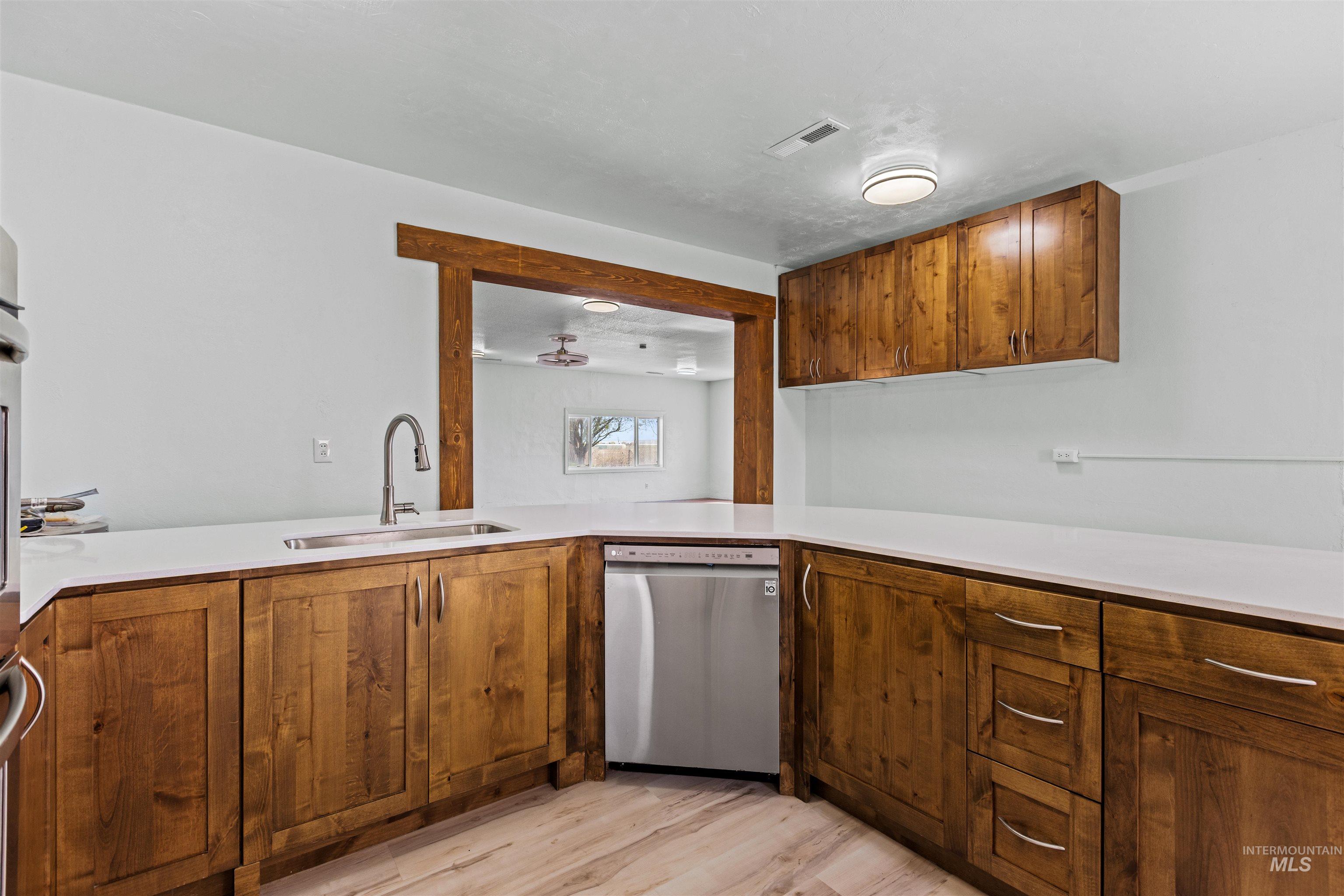 5168 South Jump Creek Road Marsing, ID 83639 - Photo 20 of 40 Kitchen with wood finish cabinets, stainless steel dishwasher, and light wood-style flooring