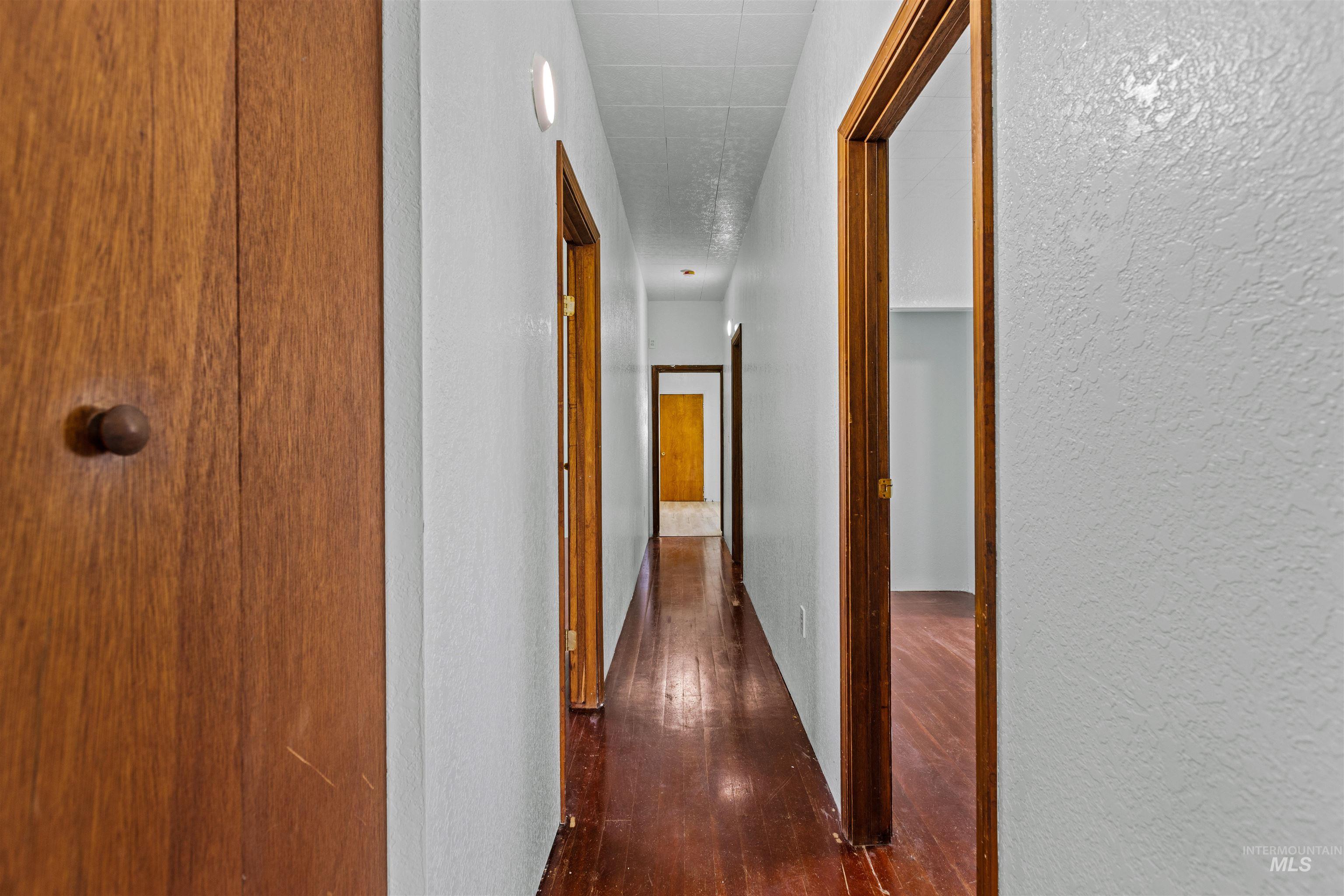 5168 South Jump Creek Road Marsing, ID 83639 - Photo 21 of 40 Corridor featuring a textured wall and dark wood finished floors