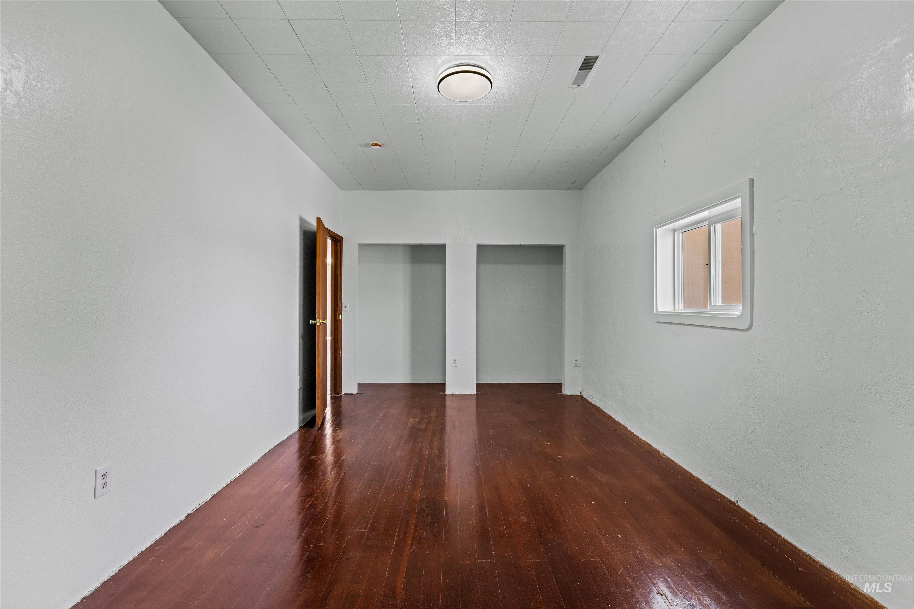 5168 South Jump Creek Road Marsing, ID 83639 - Photo 25 of 40 Unfurnished bedroom with multiple closets and dark wood-style flooring