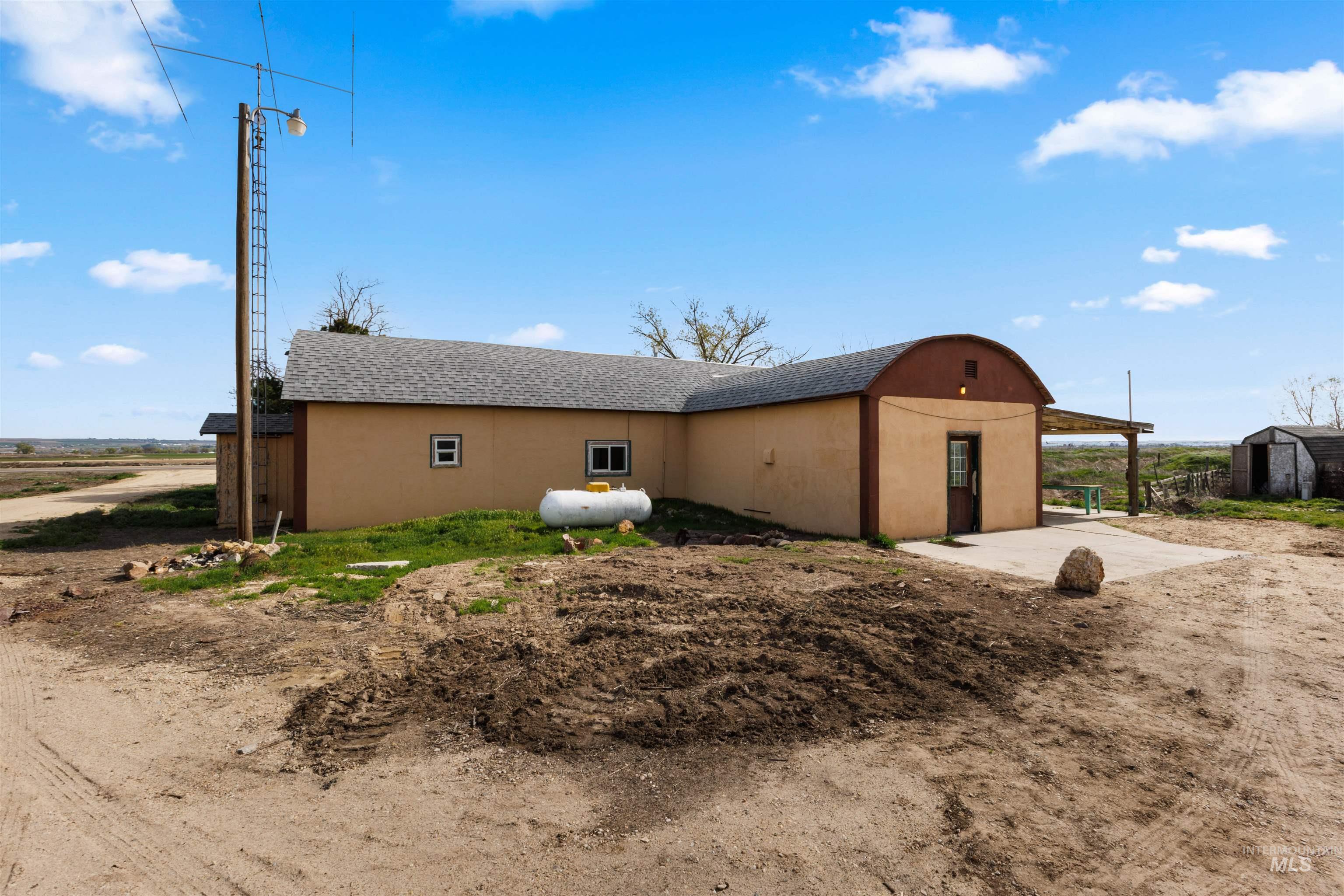5168 South Jump Creek Road Marsing, ID 83639 - Photo 34 of 40 View of property exterior with a shingled roof, a shed, a patio area, and stucco siding