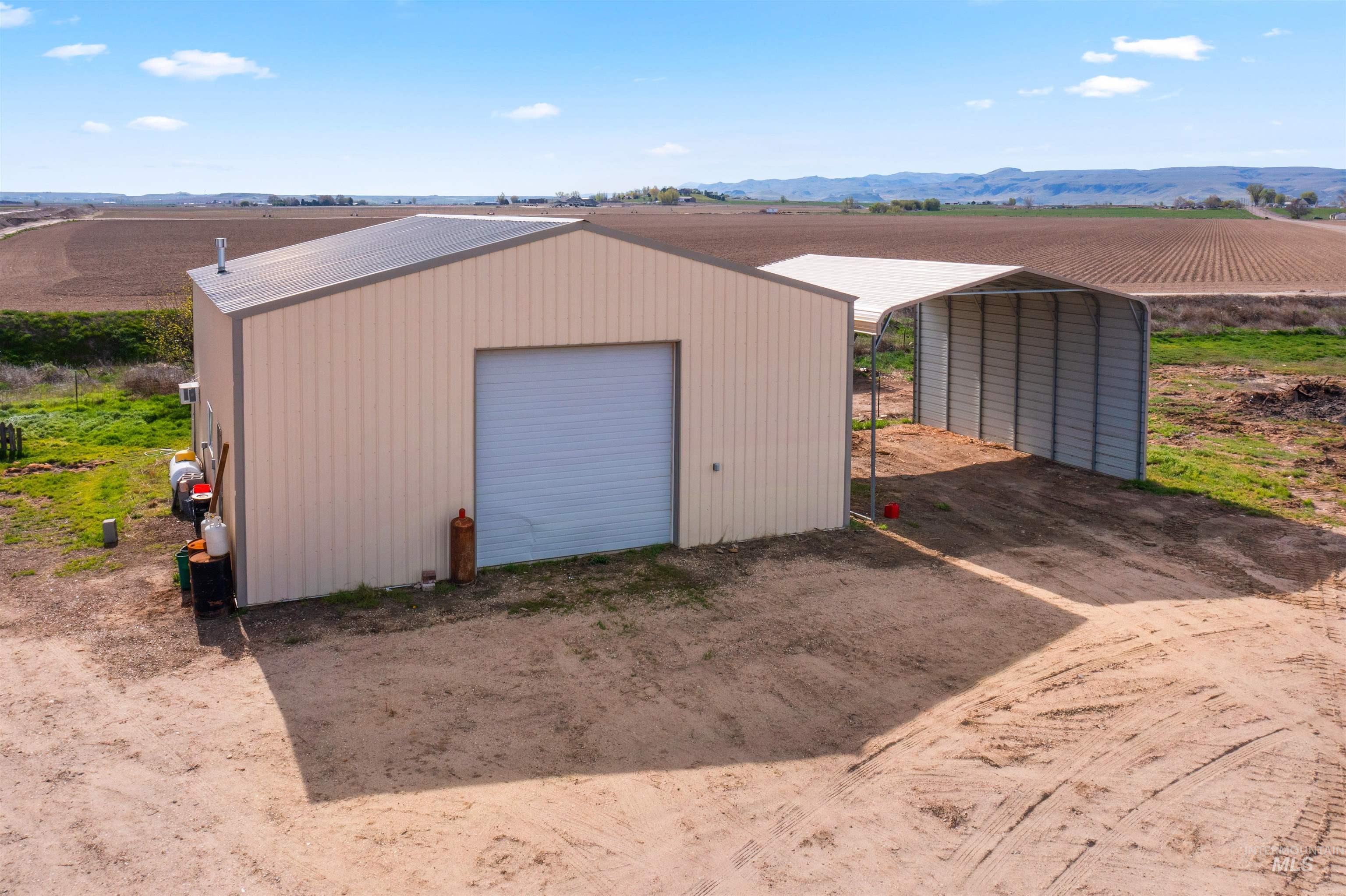 5168 South Jump Creek Road Marsing, ID 83639 - Photo 4 of 40 Detached garage with agricultural area, a view of rural / pastoral area, a mountain view, and dirt driveway