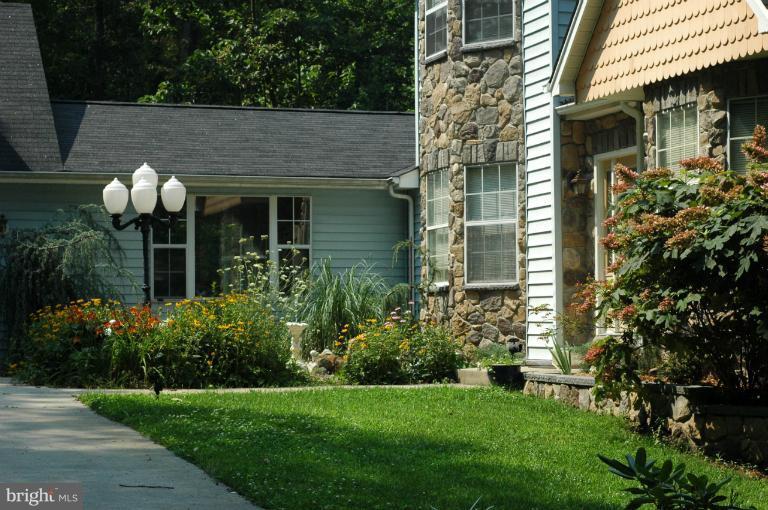 4380 Plum Point Road Huntingtown, MD 20639 - Photo 20 of 28 a front view of a house with garden