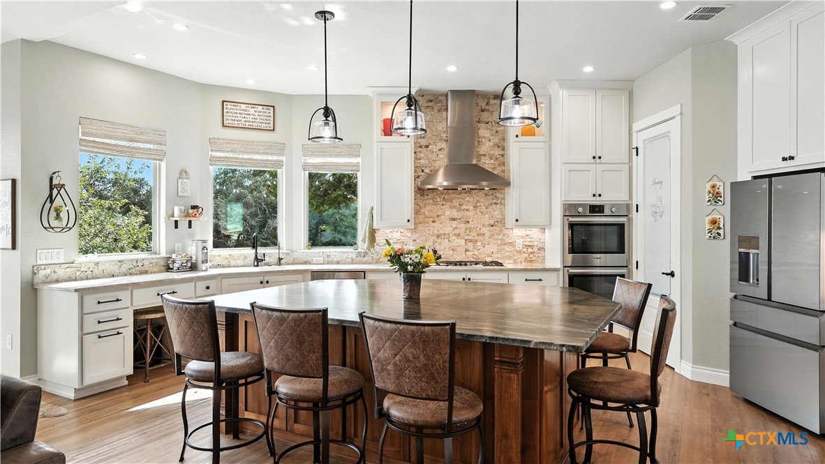 134 Stallion Estates Drive Spring Branch, TX 78070 - Photo 22 of 48 a kitchen with stainless steel appliances granite countertop a dining table chairs sink refrigerator and microwave