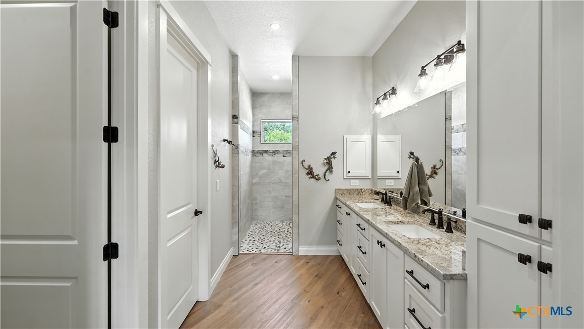 134 Stallion Estates Drive Spring Branch, TX 78070 - Photo 31 of 48 a bathroom with a double vanity sink mirror and shower