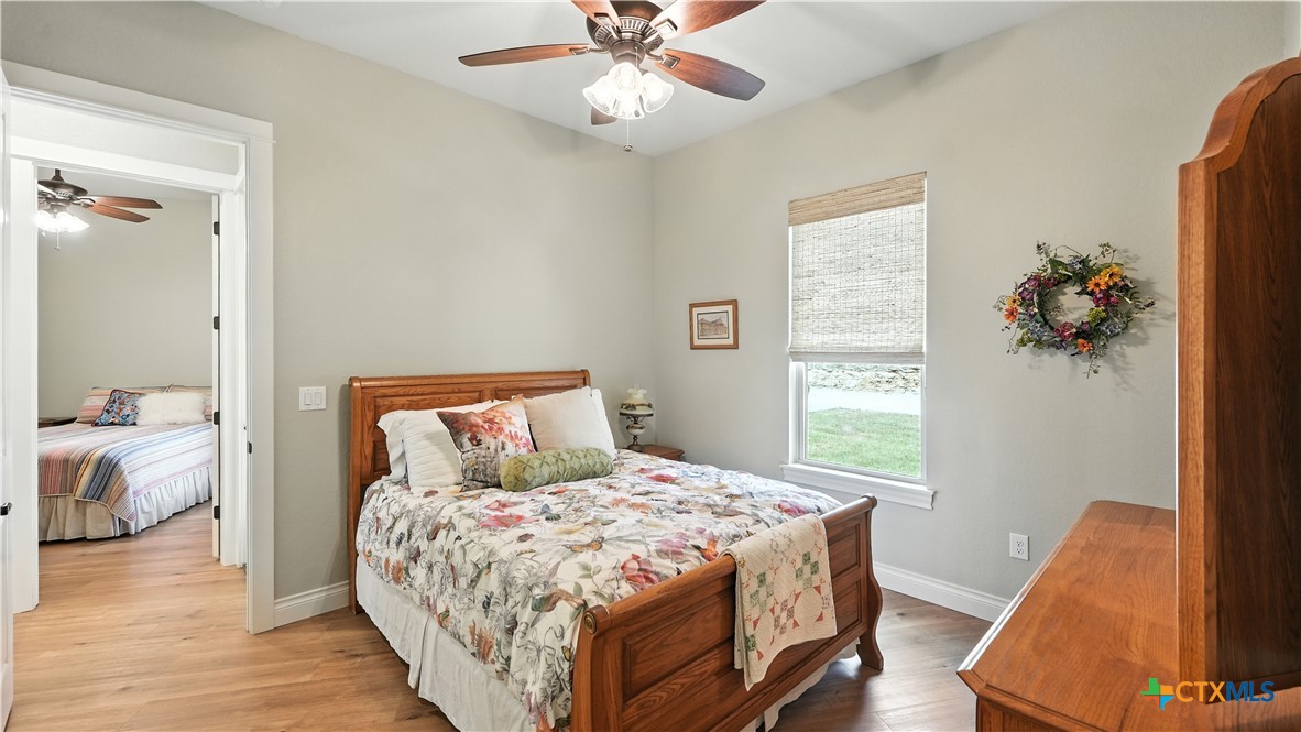 134 Stallion Estates Drive Spring Branch, TX 78070 - Photo 35 of 48 a bedroom with a bed and a large window with wooden floor